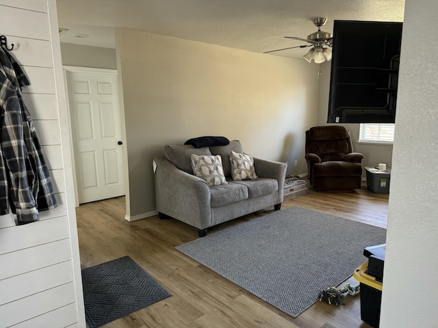 living room with ceiling fan, wood finished floors, and baseboards