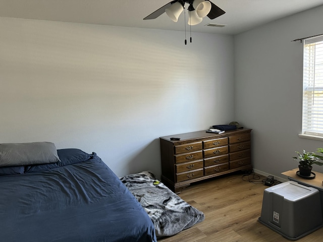 bedroom with light wood-type flooring, ceiling fan, and visible vents