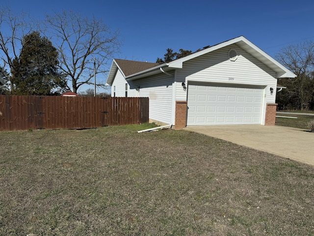 view of home's exterior with driveway, brick siding, and fence