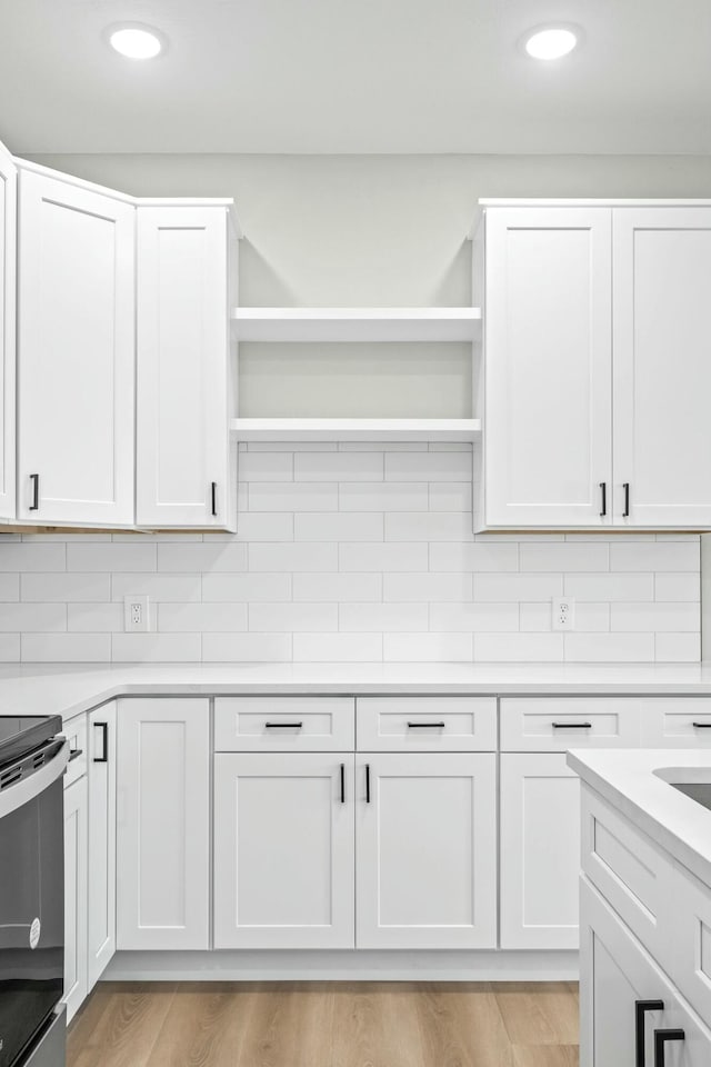 kitchen featuring open shelves, backsplash, and range with electric cooktop