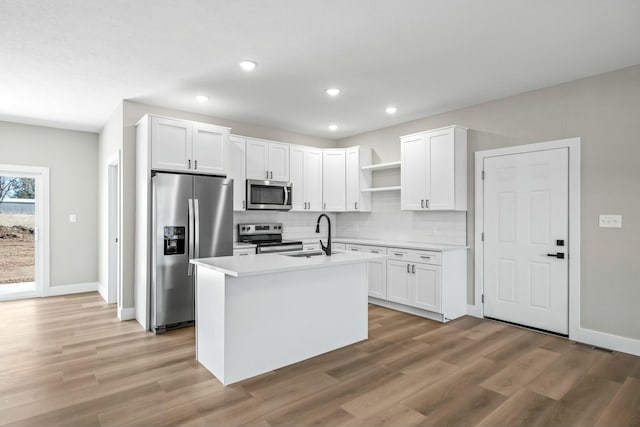 kitchen with open shelves, a sink, backsplash, white cabinetry, and stainless steel appliances