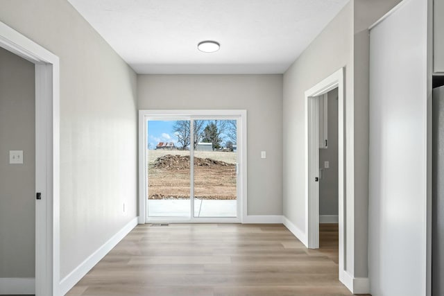 interior space featuring visible vents, light wood-type flooring, and baseboards