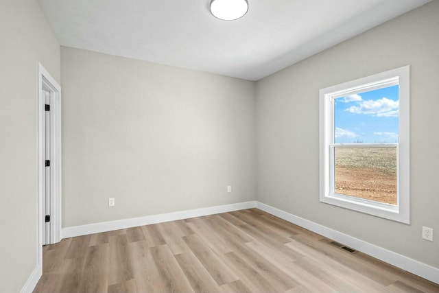 empty room with light wood-type flooring and baseboards