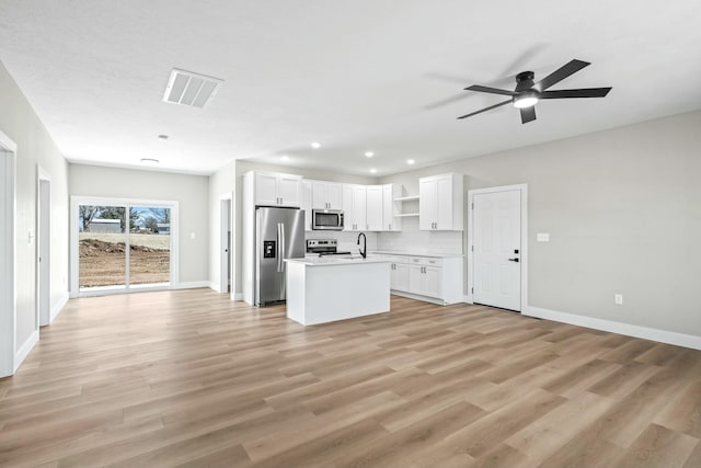 kitchen featuring visible vents, open floor plan, white cabinets, stainless steel appliances, and open shelves