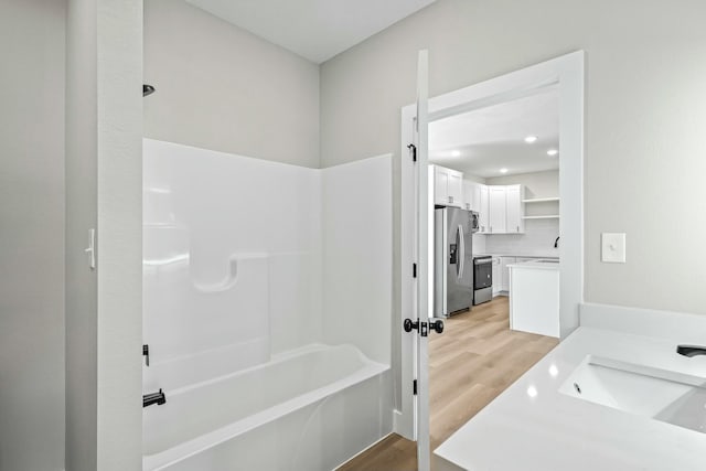 full bathroom featuring vanity, wood finished floors, and bathtub / shower combination