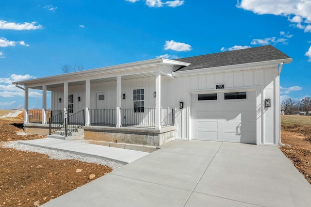 view of front of home with driveway, roof with shingles, a porch, a garage, and board and batten siding