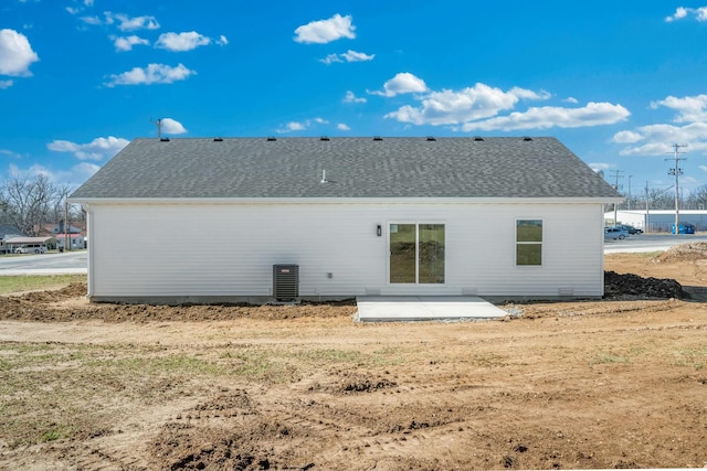 rear view of house with a patio and a shingled roof