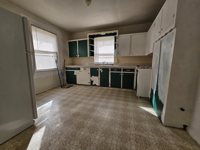 kitchen with a wealth of natural light, freestanding refrigerator, and light floors