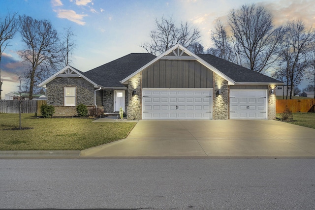 view of front of house featuring an attached garage, driveway, a front yard, and fence