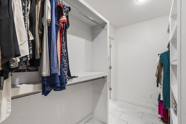 spacious closet featuring marble finish floor