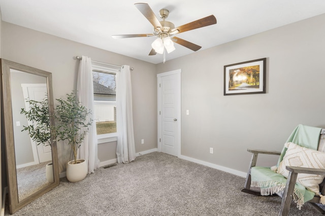 living area featuring ceiling fan, carpet floors, visible vents, and baseboards