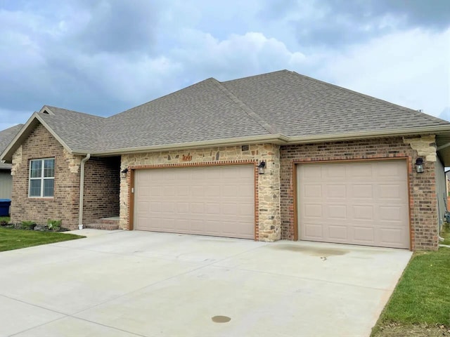 view of front of property featuring driveway, brick siding, roof with shingles, and an attached garage