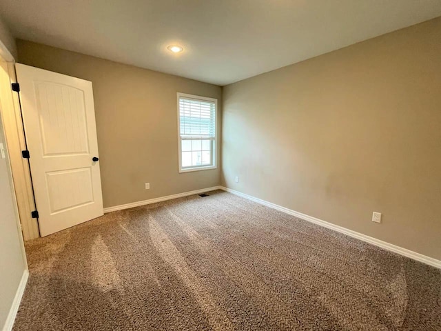 spare room featuring recessed lighting, carpet flooring, visible vents, and baseboards