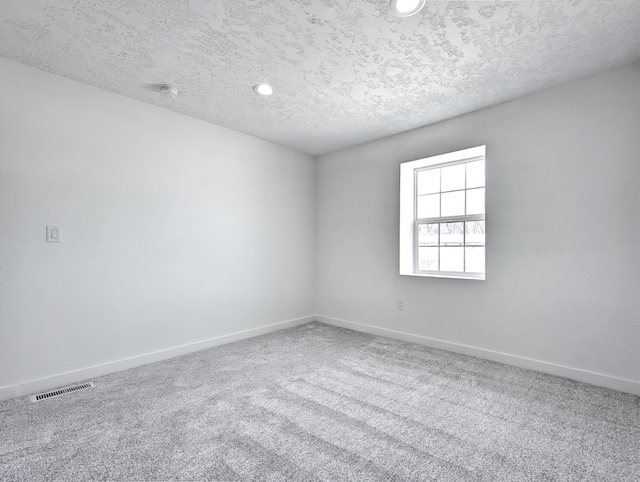 empty room with carpet floors, recessed lighting, visible vents, a textured ceiling, and baseboards