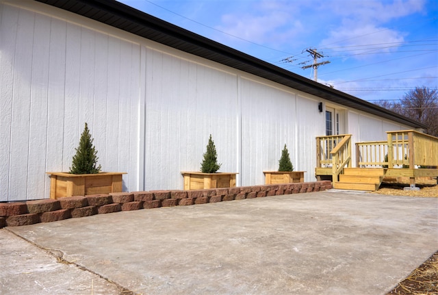 view of property exterior with a patio and a wooden deck