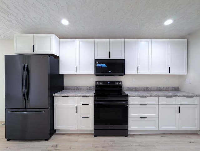 kitchen with black appliances, light wood finished floors, white cabinetry, and recessed lighting