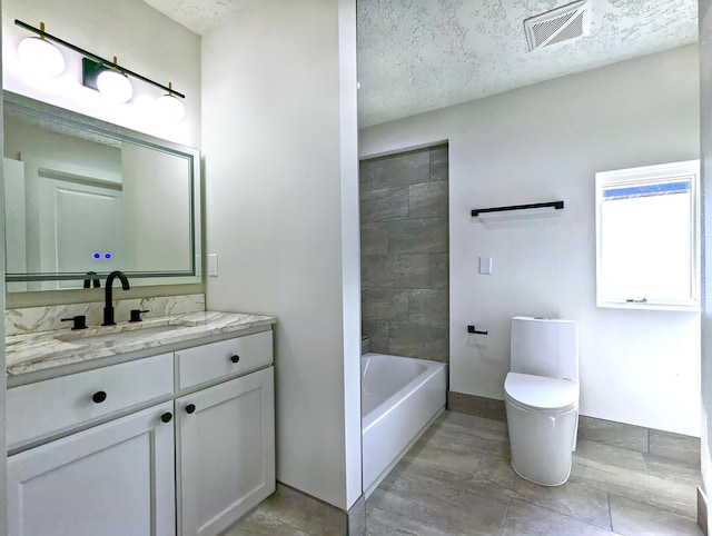 bathroom featuring visible vents, toilet, a textured ceiling, vanity, and baseboards