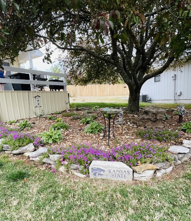 view of yard featuring central air condition unit and fence