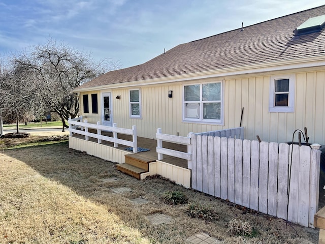 109 Lancashire Dr, Branson, MO 65616 - view of front of house featuring a front lawn, a shingled roof, a wooden deck, and board and batten siding