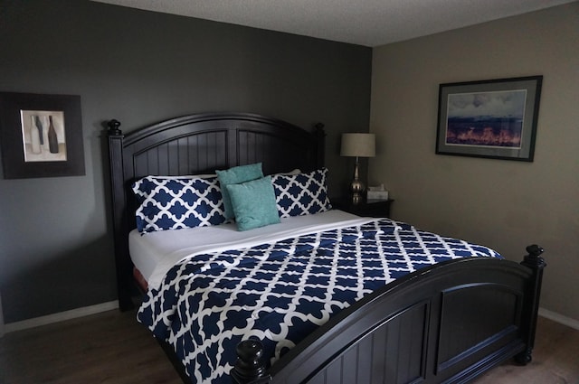 bedroom featuring wood finished floors and baseboards