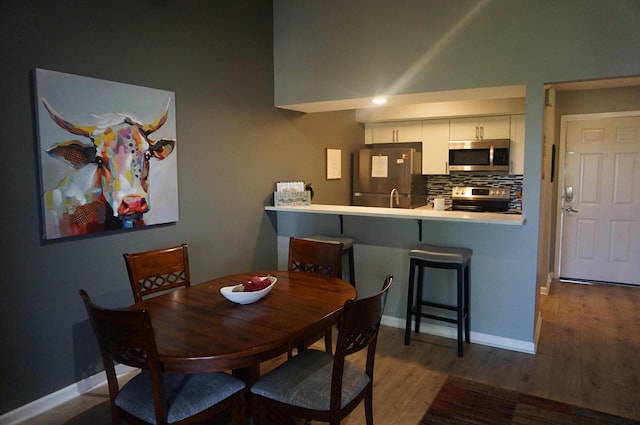 dining space featuring wood finished floors and baseboards