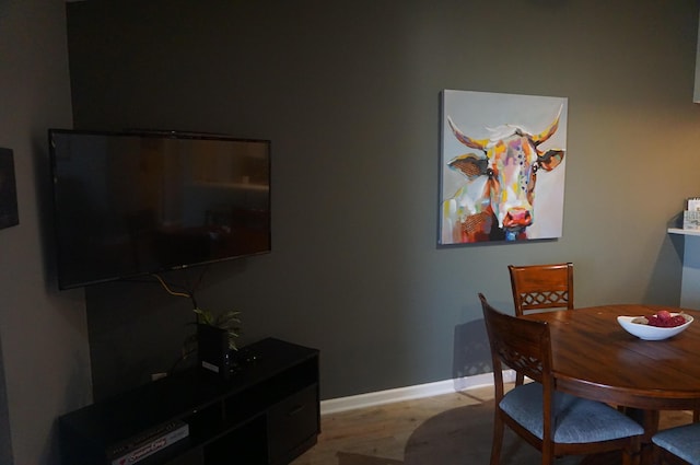 dining space featuring baseboards and wood finished floors