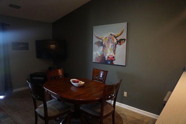 dining space featuring wood finished floors and baseboards