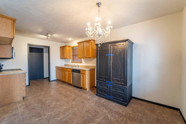 kitchen with a textured ceiling, baseboards, light countertops, appliances with stainless steel finishes, and decorative light fixtures