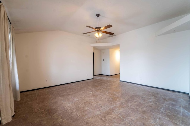 empty room featuring lofted ceiling, baseboards, and a ceiling fan