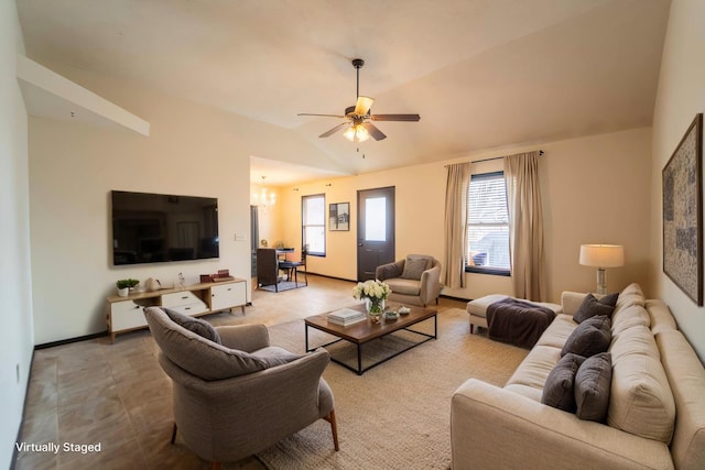 living room with vaulted ceiling, ceiling fan with notable chandelier, and baseboards