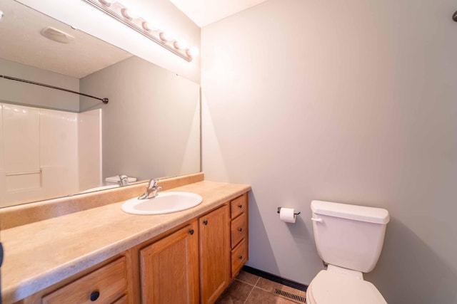 bathroom featuring toilet, visible vents, vanity, tile patterned floors, and walk in shower