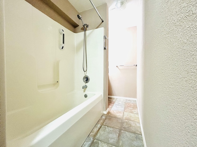 full bath featuring a textured wall, washtub / shower combination, and baseboards