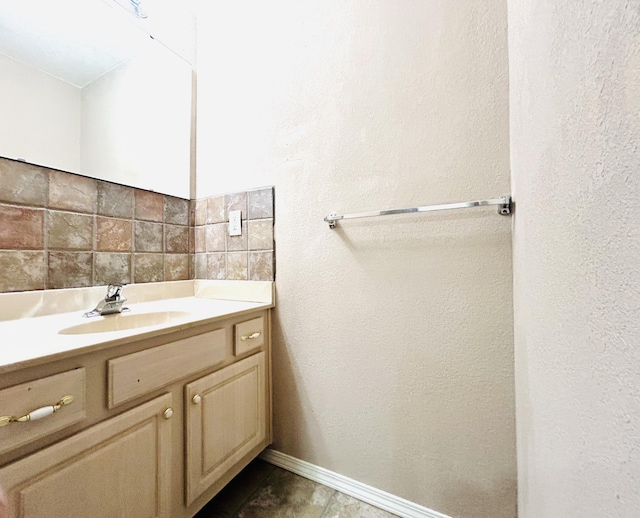 bathroom featuring backsplash, vanity, and baseboards