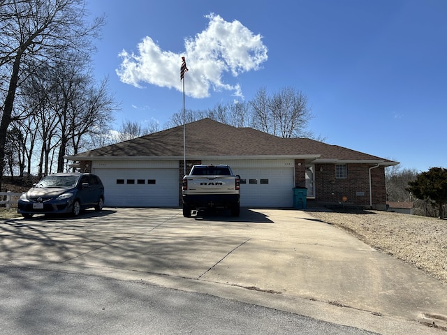 view of front facade featuring an attached garage, concrete driveway, and brick siding