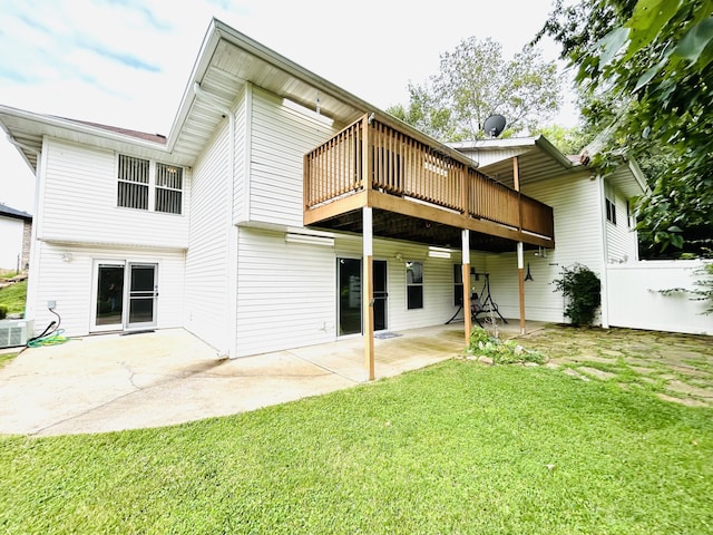 back of property featuring a deck, a lawn, a patio area, and fence