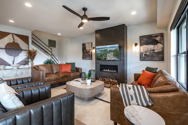 living area with ceiling fan, a tile fireplace, and recessed lighting