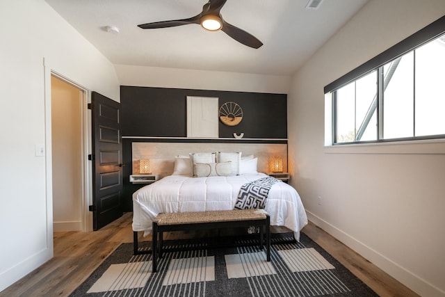 bedroom featuring a ceiling fan, baseboards, and wood finished floors