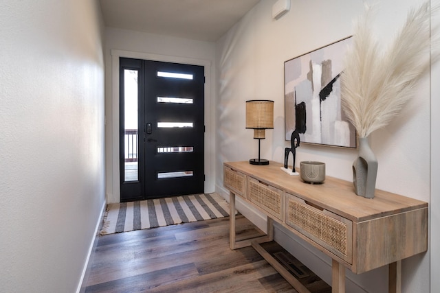 foyer with wood finished floors and baseboards