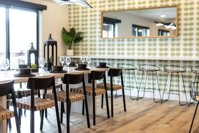 dining room featuring wallpapered walls and wood finished floors