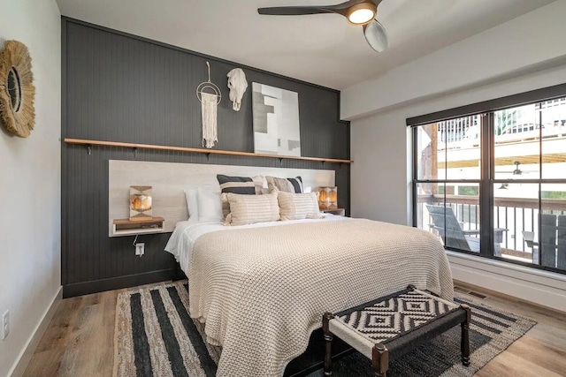 bedroom with visible vents, ceiling fan, baseboards, and wood finished floors