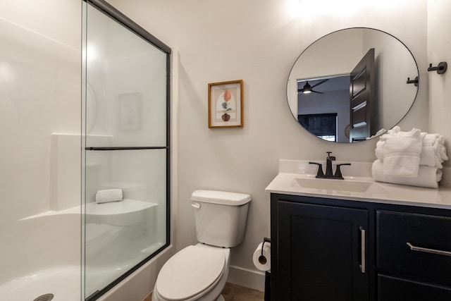 full bathroom featuring vanity, a shower stall, toilet, and baseboards