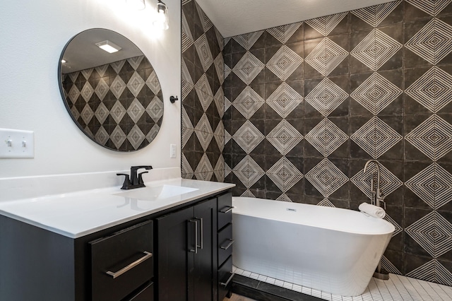 full bath with a soaking tub, tile patterned flooring, tile walls, and vanity