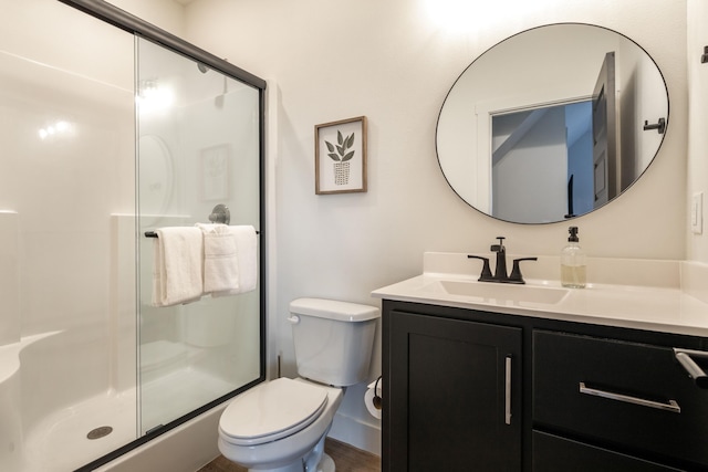 full bath featuring toilet, a stall shower, and vanity