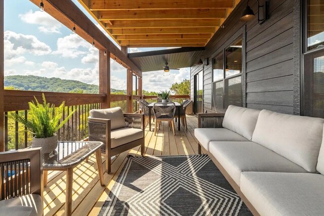 wooden terrace with an outdoor hangout area and outdoor dining area