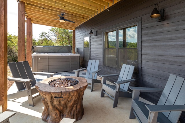 view of patio / terrace featuring a ceiling fan, a fire pit, and a hot tub