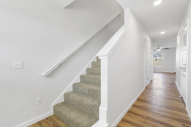 staircase featuring recessed lighting, ceiling fan, baseboards, and wood finished floors