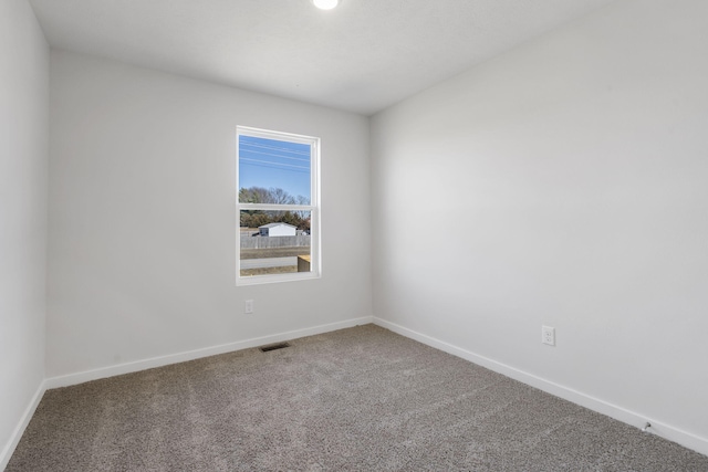 unfurnished room featuring carpet, visible vents, and baseboards