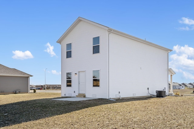 rear view of house with a patio, central AC unit, and a lawn