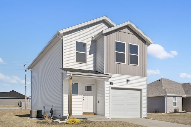 view of front of home with an attached garage, driveway, and central AC