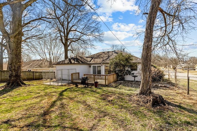 back of house featuring a fenced backyard, a yard, and a deck